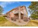 Back of home with covered patio featuring stone accents and a landscaped yard at 9784 S Iris Ct, Littleton, CO 80127