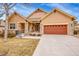 Beautiful single Gathering home with a brown facade, large driveway, and an attached garage at 9784 S Iris Ct, Littleton, CO 80127