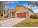 Single Gathering home with a brown facade, large driveway, and an attached garage at 9784 S Iris Ct, Littleton, CO 80127