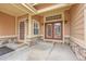 Covered porch with glass panel front door, a storm door, and stone accents at 9784 S Iris Ct, Littleton, CO 80127