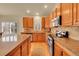 Traditional kitchen boasting wooden cabinetry, granite countertops, and stainless steel appliances at 9784 S Iris Ct, Littleton, CO 80127