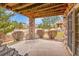 Covered patio with stone columns, wood ceiling, and outdoor seating area at 9784 S Iris Ct, Littleton, CO 80127
