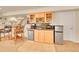 Basement wet bar area featuring wood cabinets, granite countertops, and stainless steel appliances at 9784 S Iris Ct, Littleton, CO 80127