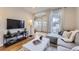 Stylish living area with hardwood floors, a modern entertainment center, and a cozy gray sofa near a bright window at 4344 Chase St, Denver, CO 80212