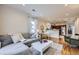 Bright and open living space with hardwood floors, a gray sofa, and an adjacent kitchen for modern living at 4344 Chase St, Denver, CO 80212