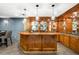 Gorgeous wet bar with ample storage, glass shelves, and unique pendant lights at 1164 S High St, Denver, CO 80210