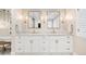 Dual vanity bathroom features white cabinetry, marble countertops, and sconce lighting at 1164 S High St, Denver, CO 80210