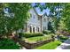 Attractive home with manicured lawn, framed flower beds, mature trees, and charming architectural design at 1164 S High St, Denver, CO 80210