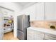 Bright kitchen features stainless steel refrigerator, white cabinets and a peek at walk-in pantry at 1164 S High St, Denver, CO 80210