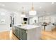 Open-concept kitchen with stainless steel appliances, large island, and seamless flow to the living area at 1164 S High St, Denver, CO 80210