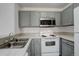 Modern kitchen featuring gray cabinets, stainless steel microwave, white countertops and appliances at 3525 28Th St # 304, Boulder, CO 80301