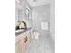 Modern bathroom with a floating vanity, marble floors, neutral walls, and bright natural lighting at 5920 W 91St Ave, Westminster, CO 80031