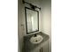 Well-lit bathroom featuring a granite countertop and a black framed mirror at 59440 E 56Th Ave, Strasburg, CO 80136