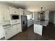 Modern kitchen features stainless steel appliances, an island with granite countertop, and custom white cabinets at 59440 E 56Th Ave, Strasburg, CO 80136