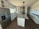 Spacious kitchen featuring white cabinets, stainless steel appliances, granite countertops, and a center island at 59440 E 56Th Ave, Strasburg, CO 80136