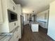 Open kitchen with stainless appliances, white cabinets, granite countertops, large island, and wood look floors at 59440 E 56Th Ave, Strasburg, CO 80136