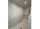 Bright shower space with a white marble-patterned tile and a shower caddy at 59440 E 56Th Ave, Strasburg, CO 80136