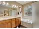 This bathroom features dual sinks, white tiled tub, and window for natural light at 21270 E Eldorado Dr, Aurora, CO 80013