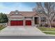 Charming home featuring stone accents, red garage doors, and a well-maintained lawn at 21270 E Eldorado Dr, Aurora, CO 80013