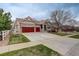 Charming exterior with stone accents, red garage doors, and a well-manicured lawn at 21270 E Eldorado Dr, Aurora, CO 80013