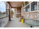 Inviting covered porch featuring stone pillars and cozy outdoor seating area at 21270 E Eldorado Dr, Aurora, CO 80013