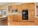 Kitchen area featuring light wood cabinetry, stainless steel appliances, and double oven at 21270 E Eldorado Dr, Aurora, CO 80013