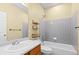 Well-lit bathroom featuring a tub with gray tile surround, wood vanity, and neutral paint at 9814 Norfolk St, Commerce City, CO 80022