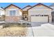 Charming home featuring a brick facade, a two-car garage and a well-maintained yard with mature landscaping at 9814 Norfolk St, Commerce City, CO 80022
