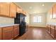 Bright kitchen featuring wood cabinets, light countertops, modern appliances, and hardwood floors at 9814 Norfolk St, Commerce City, CO 80022