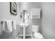 Contemporary powder room featuring pedestal sink, oval mirror, and wall-mounted storage cabinet at 2899 N Speer Blvd # 203, Denver, CO 80211