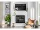 Stylish fireplace with mounted TV and decorative accents, with leather chair and plants at 2899 N Speer Blvd # 203, Denver, CO 80211