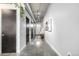 Long hallway with concrete floors, gray walls, exposed ducts, and black doors for an industrial-chic feel at 2899 N Speer Blvd # 203, Denver, CO 80211