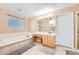 Bright bathroom featuring a soaking tub, vanity with ample counter space, and neutral tile flooring at 10089 Wynwood Way, Highlands Ranch, CO 80126