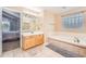 Well-lit bathroom with a soaking tub and adjacent vanity, next to the main bedroom at 10089 Wynwood Way, Highlands Ranch, CO 80126