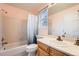 Well-lit bathroom featuring a bathtub and shower, a vanity with a sink, and tiled walls at 10089 Wynwood Way, Highlands Ranch, CO 80126