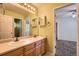Bathroom with a double sink vanity, neutral decor, and an open doorway to an adjacent room at 10089 Wynwood Way, Highlands Ranch, CO 80126