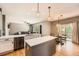Open-concept kitchen with quartz countertops, stainless steel appliances, island, and eat-in area seamlessly flows into the living room at 10089 Wynwood Way, Highlands Ranch, CO 80126