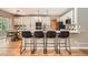 Modern kitchen features a breakfast bar with seating, pendant lighting, stainless steel appliances, and a dining area nearby at 10089 Wynwood Way, Highlands Ranch, CO 80126