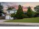 Attractive home showcasing a lush front lawn, established trees, and a double garage at 1775 S Memphis St, Aurora, CO 80017