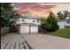 Inviting home featuring a two-car garage, mature trees, and a well-maintained lawn at 1775 S Memphis St, Aurora, CO 80017