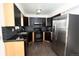 Modern kitchen with sleek, dark cabinetry, granite countertops, and stainless steel appliances at 1775 S Memphis St, Aurora, CO 80017
