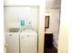 Convenient laundry area with washer, dryer, and storage shelving near the bathroom at 1775 S Memphis St, Aurora, CO 80017
