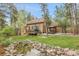 Expansive backyard featuring a well-maintained lawn, pond, deck, and covered patio for outdoor enjoyment at 171 Columbine St, Larkspur, CO 80118