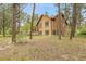 Exterior of a home surrounded by mature trees, showcasing its unique design and natural setting at 171 Columbine St, Larkspur, CO 80118