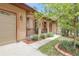 Charming home entrance with manicured landscaping, arched doorway, and a welcoming front porch at 171 Columbine St, Larkspur, CO 80118