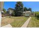 A lush backyard features a greenhouse, mature trees, and a well-maintained lawn at 1665 S Madison St, Denver, CO 80210