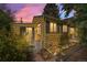 Charming yellow home featuring a white picket fence, siding, and black shuttered windows, nestled under a colorful sky at 1665 S Madison St, Denver, CO 80210