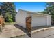 Outside shot of garage with white siding and an adjacent wooden gate at 1665 S Madison St, Denver, CO 80210