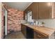 The kitchen features wood counters, vintage cabinets, and a brick accent wall at 1665 S Madison St, Denver, CO 80210