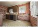 An angle view of the kitchen offering brick walls, windows, and patterned floors at 1665 S Madison St, Denver, CO 80210